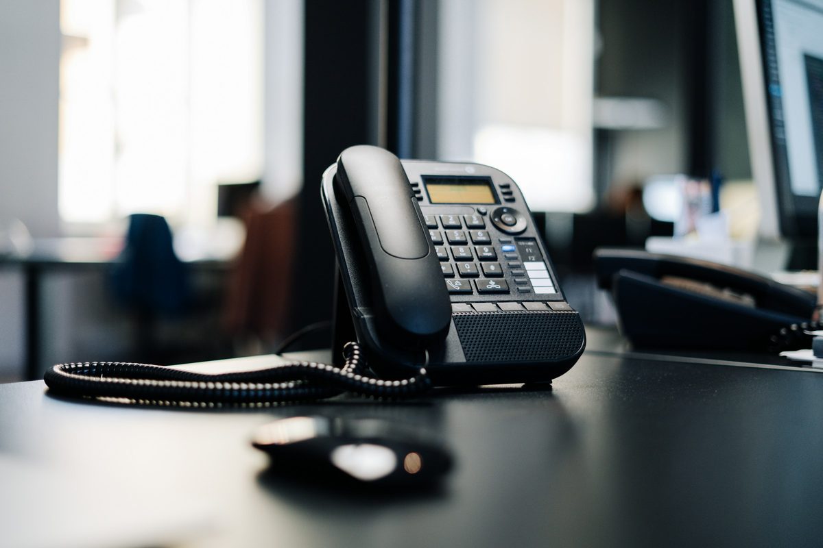 A desk telephone on an office desk, photographed close up