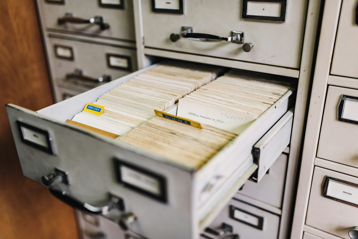 An open filing cabinet drawer packed with index cards and paper records