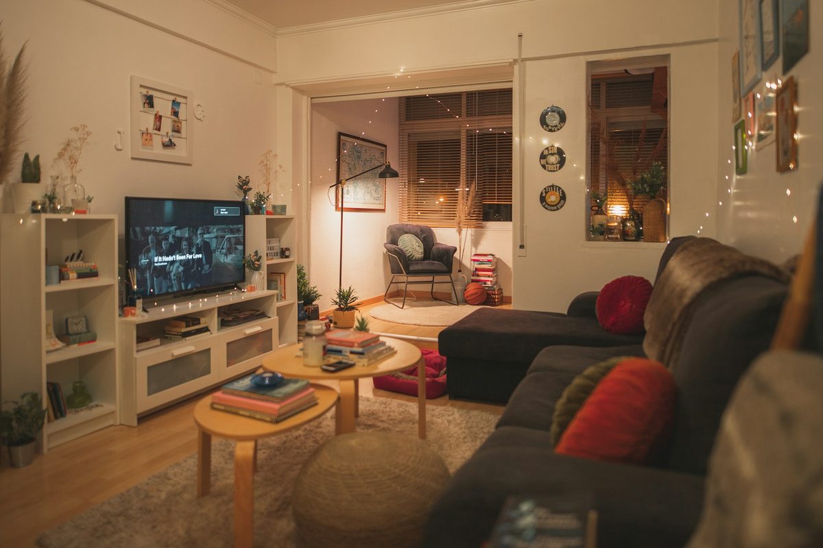 A warmly lit living room in the evening with a television switched on